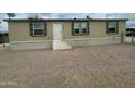Tan home featuring three windows and a front entrance with a gravel lot at 10231 E Illini St, Mesa, AZ 85208