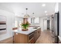 Bright kitchen with stainless steel appliances, large island with seating, and wood cabinets at 12 E Seminole Dr, Phoenix, AZ 85022