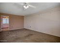 Spacious carpeted bedroom with ceiling fan and closet storage shelves at 13632 N Silverbell Dr, Sun City, AZ 85351