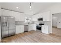 Bright kitchen featuring stainless steel appliances, white cabinets, and wood-look flooring at 15715 W Cottonwood St, Surprise, AZ 85374