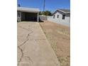 Long concrete driveway leading up to the carport, and a dry, low-maintenance front yard at 1630 E Catalina Dr, Phoenix, AZ 85016