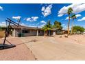 Lovely home with a spacious driveway and xeriscaped front yard, complemented by mature trees at 1650 E Gary St, Mesa, AZ 85203