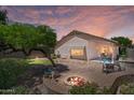 Inviting backyard with a fire pit, lush landscaping, and ample seating for outdoor enjoyment at 1761 E Countrywalk Ln, Chandler, AZ 85225