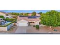 Well-maintained home featuring solar panels, a two-car garage, and a beautifully xeriscaped front yard at 18161 N 63Rd Ln, Glendale, AZ 85308
