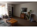 Well-lit living room with a comfortable couch, wooden table, and mounted TV at 1927 E Hampton Ave # 208, Mesa, AZ 85204