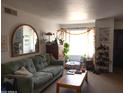 Inviting living room with a couch, wooden table, and lots of plants at 1927 E Hampton Ave # 208, Mesa, AZ 85204