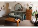 Cozy living room with a green sofa, arched mirror, and wooden side table at 1927 E Hampton Ave # 208, Mesa, AZ 85204