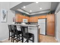 Modern kitchen with wood cabinets, stainless steel appliances, and breakfast bar seating at 2201 N Comanche Dr # 1094, Chandler, AZ 85224