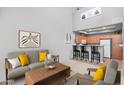 Open-concept living room with a modern kitchen, neutral decor, and breakfast bar seating at 2201 N Comanche Dr # 1094, Chandler, AZ 85224