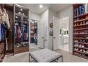 Spacious walk-in closet with custom shelving and storage, including an ottoman, offering ample organization at 22858 E Silver Creek Ln, Queen Creek, AZ 85142