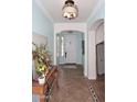 Bright foyer with tile flooring, arched doorways, elegant lighting, and a decorative console table at 2413 S 121St Dr, Avondale, AZ 85323