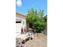 Inviting front entrance with a stone bench, potted plants, and decorative metal sculptures at 2413 S 121St Dr, Avondale, AZ 85323