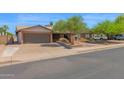 Single-story home boasts a spacious driveway, attached two-car garage, and desert landscaping at 2524 E Elmwood St, Mesa, AZ 85213
