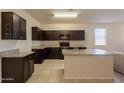 Beautiful kitchen with dark cabinets, granite countertops, and a central island with a sink at 29870 W Weldon Ave, Buckeye, AZ 85396