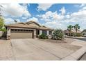 Single-story home featuring a two-car garage and desert landscaping against a vibrant sky at 29915 N Maravilla Dr, San Tan Valley, AZ 85143