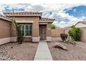 A quaint tan home featuring desert landscaping, with a sidewalk leading to the front door at 3212 W Lucia Dr, Phoenix, AZ 85083