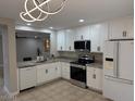 Bright kitchen features modern appliances, granite countertops, white cabinetry, and tile flooring at 3212 W Lucia Dr, Phoenix, AZ 85083
