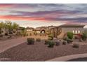 Desert landscaping surrounds this luxury home with an arched entryway and tile roof at 3217 N Piedra Cir, Mesa, AZ 85207