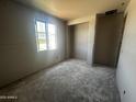 An unfinished bedroom in a new home build with drywall walls, gray flooring and an alcove for a closet at 32615 N Newby Dr, San Tan Valley, AZ 85143