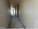 A hallway in a new home build with gray flooring and drywall walls going to the other side of the house at 32615 N Newby Dr, San Tan Valley, AZ 85143