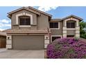 Charming home showcasing a two-car garage and a vibrant, purple blooming shrub in the front yard at 3730 S Chaparral Rd, Apache Junction, AZ 85119