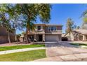Charming two-story home features a well-manicured lawn and mature shade tree at 424 W Midland Ln, Gilbert, AZ 85233