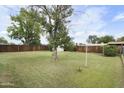 Expansive backyard featuring a grassy lawn, mature trees, and a wooden fence for privacy at 549 N Olive --, Mesa, AZ 85203