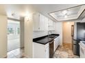 Bright kitchen equipped with white cabinetry, stainless steel appliances, and neutral tile flooring at 5809 E Thomas Rd, Scottsdale, AZ 85251