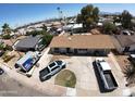 Aerial view of a house with a circular driveway and three cars parked outside on a sunny day at 6823 W Garfield St, Phoenix, AZ 85043