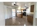 Kitchen with stainless steel appliances, wood cabinets, and a sliding glass door with access to the outside at 6823 W Garfield St, Phoenix, AZ 85043