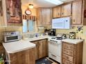 Traditional-style kitchen featuring oak cabinets, white appliances and countertops, and a double basin sink at 7750 E Broadway Rd # 123, Mesa, AZ 85208