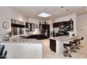 Bright kitchen features an eat-in granite counter, stainless appliances, and dark wood cabinetry at 8230 E Via Del Sol Dr, Scottsdale, AZ 85255