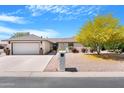 Charming single-story home featuring a well-manicured front yard and a two-car garage at 9621 E Calgary Ave, Sun Lakes, AZ 85248