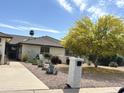 Charming home exterior with desert landscaping, rock mulch, and mature desert foliage at 9621 E Calgary Ave, Sun Lakes, AZ 85248