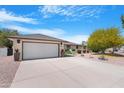 Charming single-story home featuring a well-manicured front yard and a two-car garage at 9621 E Calgary Ave, Sun Lakes, AZ 85248