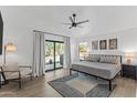 Bright main bedroom with a ceiling fan, neutral decor, and sliding glass door to the backyard at 108 E Horseshoe Ave, Gilbert, AZ 85296