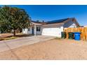 This inviting home boasts a spacious driveway and a clean, white exterior with solar panels for energy efficiency at 13039 N 19Th Ave, Phoenix, AZ 85029