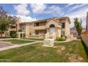 Attractive condo with red tile roof, manicured lawn, mature landscaping, and charming front entrance at 1333 E Morten Ave # 230, Phoenix, AZ 85020