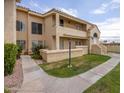 Inviting stucco condo with red tile roof and a beautifully landscaped front lawn with sidewalk at 1333 E Morten Ave # 230, Phoenix, AZ 85020