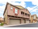 Charming home exterior showcasing stone accents, multiple garage doors, and cozy upper-level balconies at 1350 S Greenfield Rd # 1125, Mesa, AZ 85206