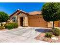 Attractive single-story home featuring a landscaped front yard, a driveway, and an attached two-car garage at 1361 N Claiborne --, Mesa, AZ 85205