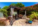 Gazebo features outdoor furniture and shade curtains, surrounded by lush backyard landscaping at 1361 N Claiborne --, Mesa, AZ 85205