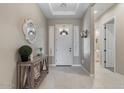 Inviting foyer with tiled floor, console table, and decorative mirror, creating a welcoming entrance at 14634 W Wethersfield Rd, Surprise, AZ 85379