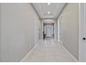 Bright hallway features neutral walls, modern lighting, and white trim, leading to various rooms in the home at 14634 W Wethersfield Rd, Surprise, AZ 85379