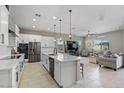 Open-concept kitchen with large island, stainless steel appliances, and modern white cabinets, perfect for entertaining at 14634 W Wethersfield Rd, Surprise, AZ 85379