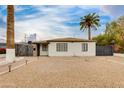 Exterior view showcasing the home's white facade, desert landscaping, and secure gated entry at 1529 E Edgemont Ave, Phoenix, AZ 85006