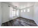 Bright living room featuring hardwood floors and large window with views of the front yard at 15365 W Valentine St, Surprise, AZ 85379