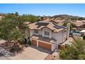 An elevated view of the tan, two-story home featuring a two-car garage and solar panels, with a pool in the backyard at 15829 S 13Th Pl, Phoenix, AZ 85048