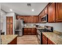 Well-equipped kitchen with stainless steel appliances, granite countertops, and rich wood cabinetry at 16055 S 18Th Dr, Phoenix, AZ 85045