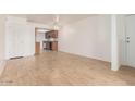 Bright living room featuring hardwood floors and a glimpse of the adjacent kitchen, creating an open and inviting space at 16602 N 25Th St # 223, Phoenix, AZ 85032